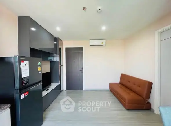 Modern living room with sleek black cabinetry and brown leather sofa