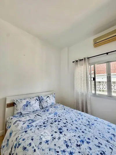 Cozy bedroom with floral bedding and natural light from window