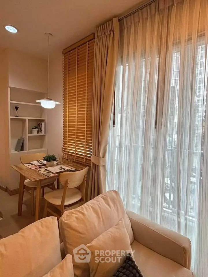 Cozy living room with dining area, featuring soft lighting and elegant curtains for a warm ambiance.