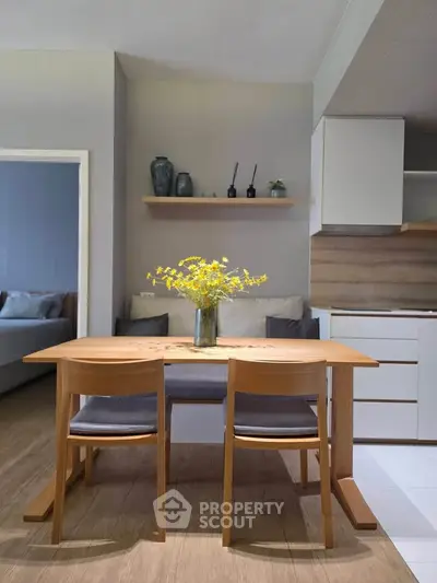 Modern dining area with wooden table and chairs, featuring a cozy open layout and stylish decor.