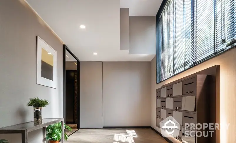 Modern apartment entrance with sleek mailboxes and natural light