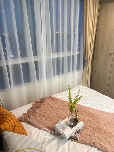 Cozy bedroom with city view, elegant decor, and soft lighting for a relaxing ambiance.