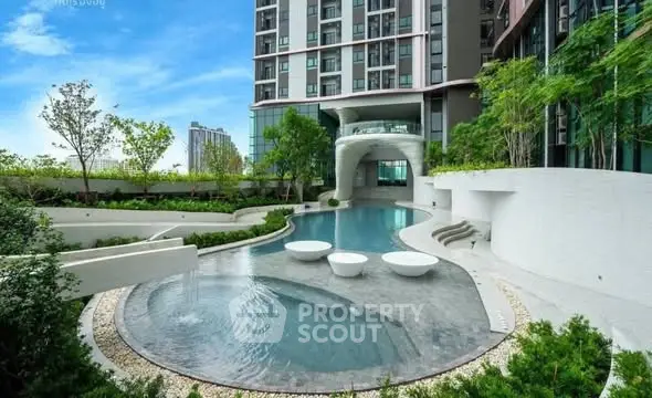 Luxurious modern apartment building with stunning pool and lush greenery.