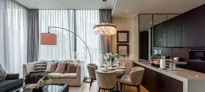 Luxurious modern living room with elegant decor and open kitchen layout, featuring stylish furniture and ambient lighting.