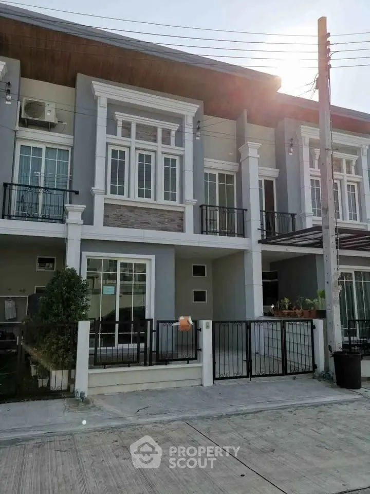 Modern townhouse exterior with stylish facade and balcony, perfect for urban living.