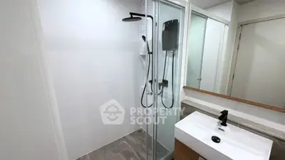 Modern bathroom with sleek shower and stylish sink in contemporary apartment.