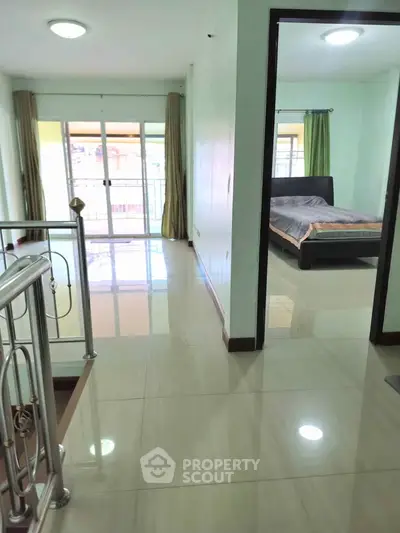Spacious bedroom with balcony access and polished floors in modern apartment.