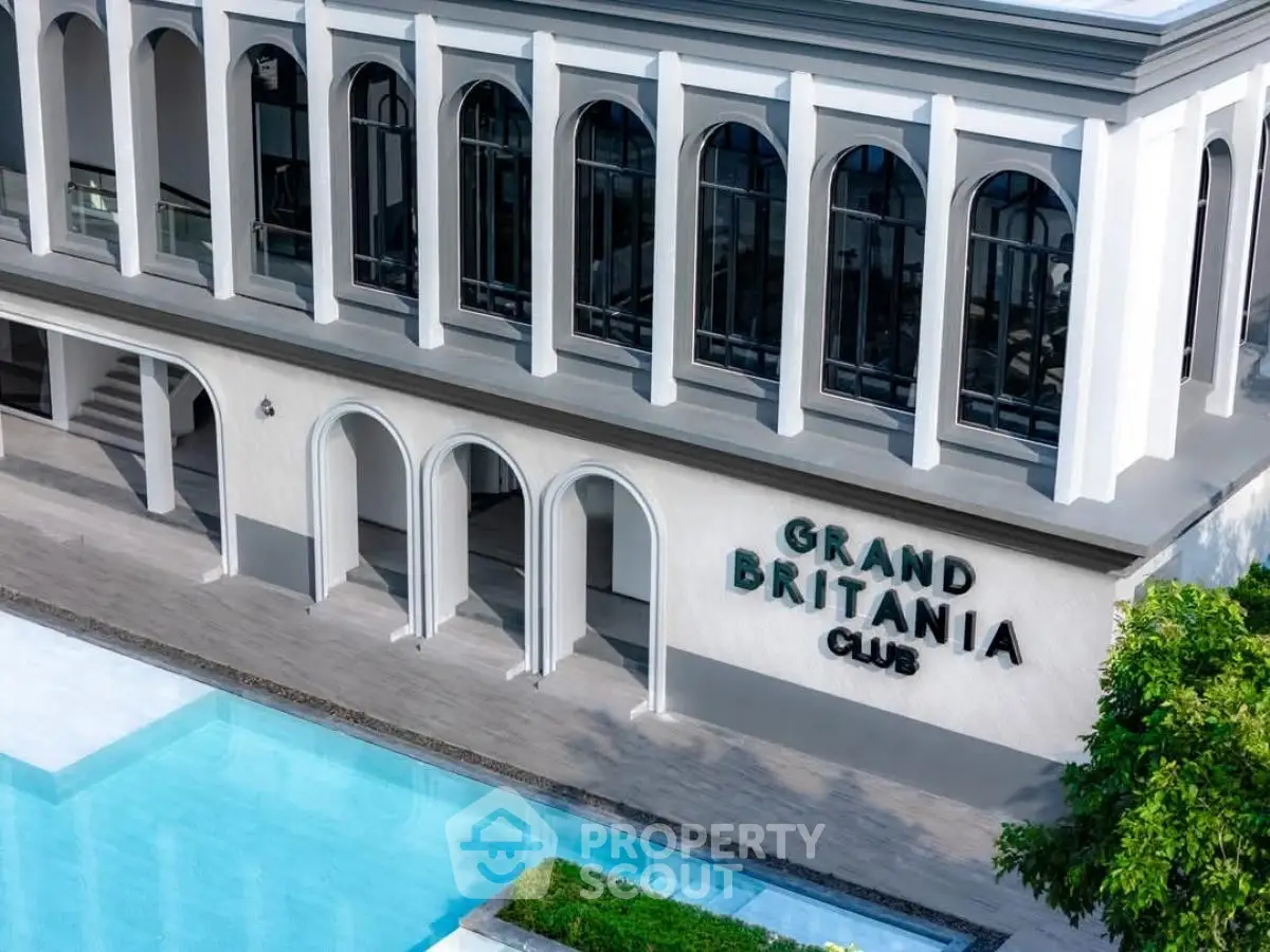 Elegant exterior of Grand Britania Club with pool and modern architecture.