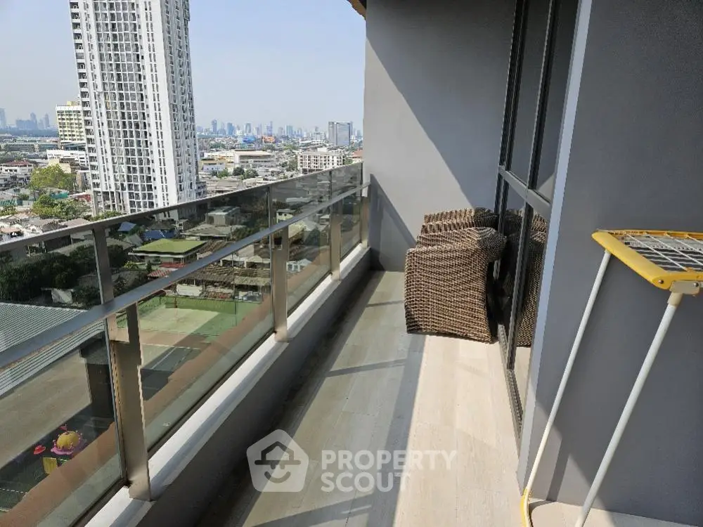 Spacious balcony with modern wicker chair overlooking a bustling cityscape, perfect for outdoor relaxation and urban living.