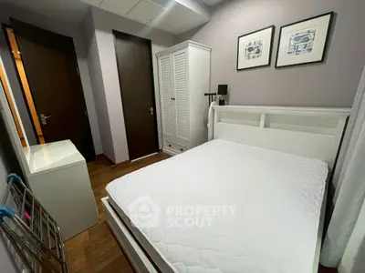 Cozy bedroom with white furniture and wooden flooring, perfect for restful nights.