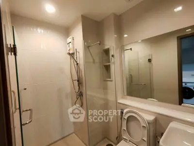 Modern bathroom with glass shower and sleek fixtures in a contemporary apartment.