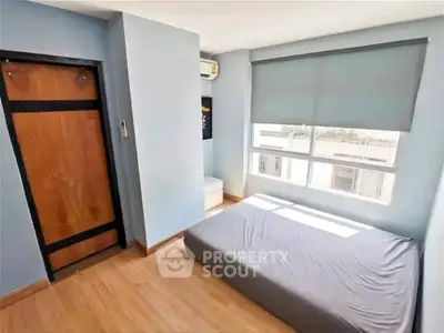 Bright and cozy bedroom with large window and minimalist design