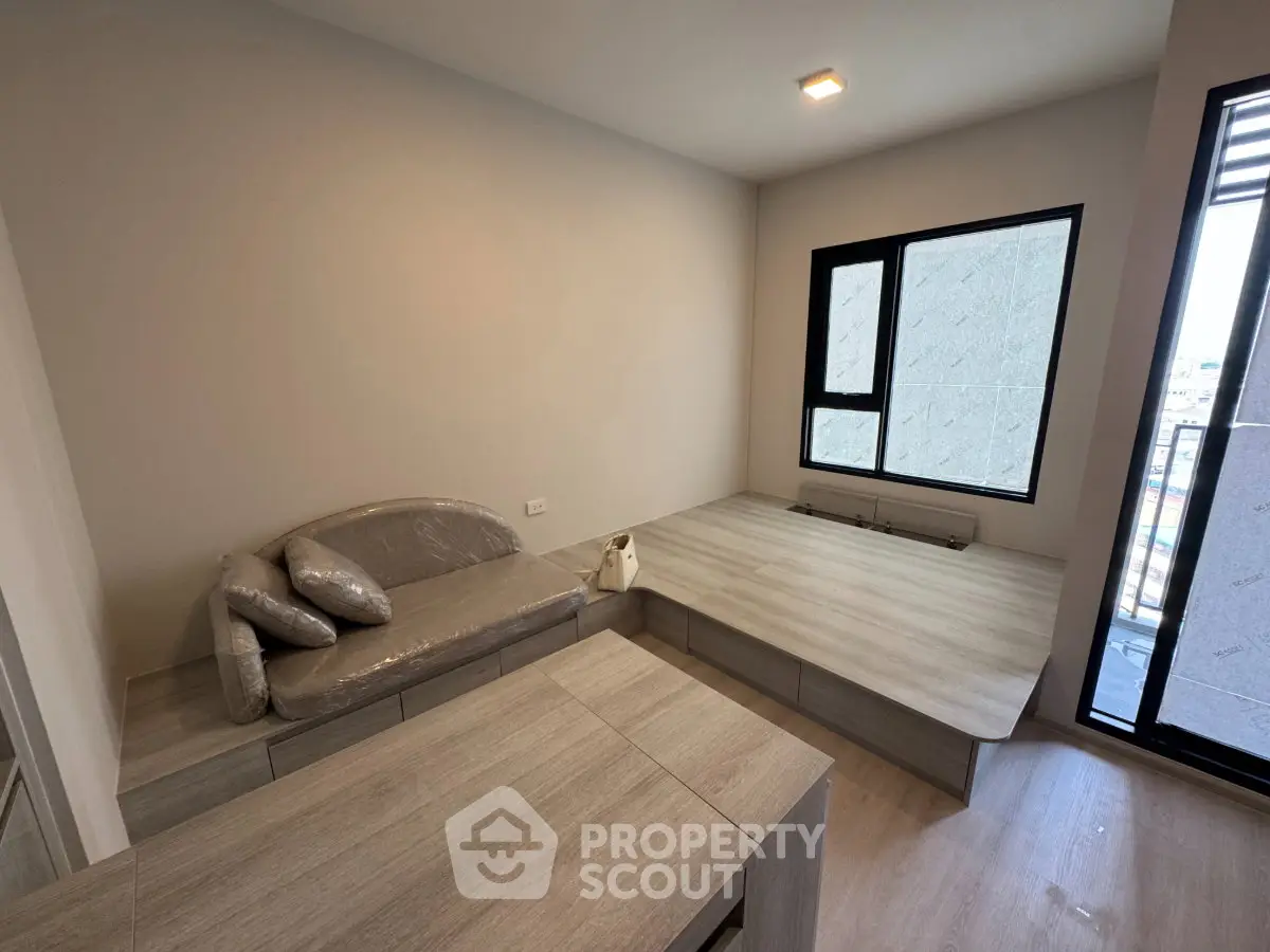 Modern minimalist living room with sleek furniture and large window for natural light.