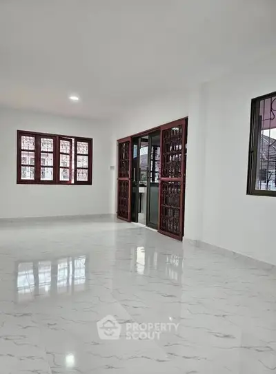 Spacious empty living room with marble flooring and large windows