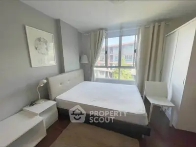 Bright and cozy bedroom with large window and modern furnishings in a stylish apartment.