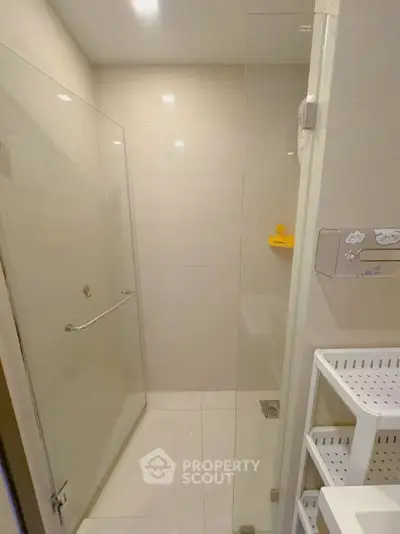 Modern bathroom with glass shower enclosure and sleek storage shelves