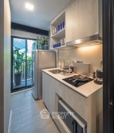 Modern kitchen with sleek design and balcony view, featuring built-in appliances and stylish decor.