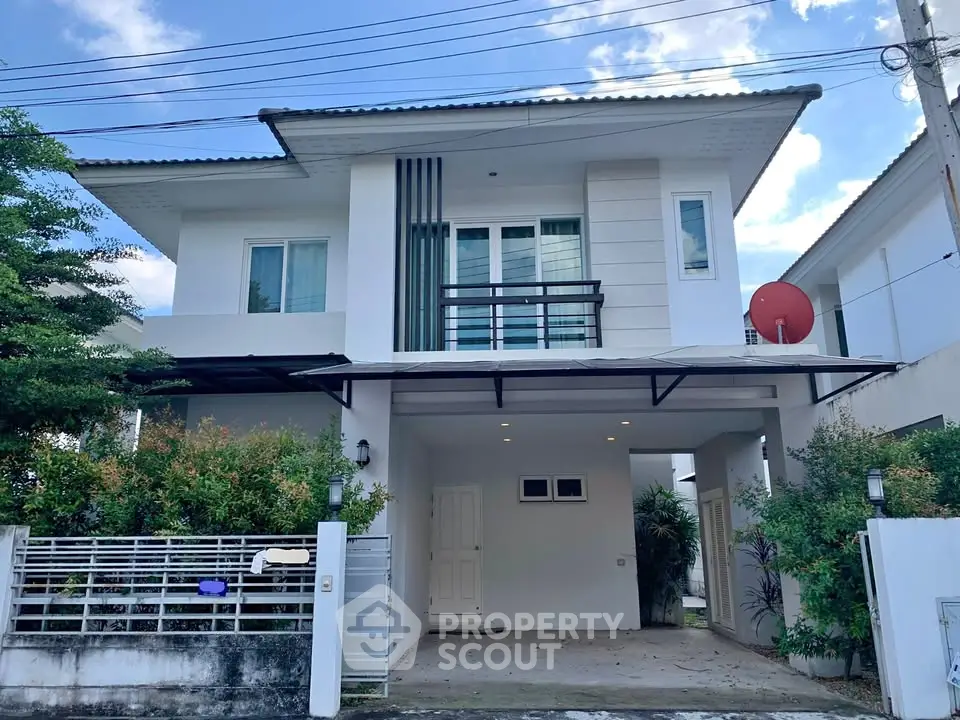 Modern two-story house with balcony and garage in a serene neighborhood.