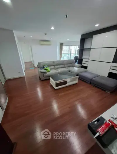 Spacious modern living room with sleek wooden flooring and stylish furniture