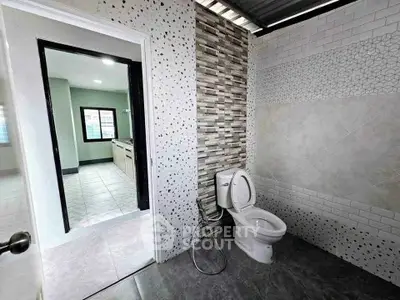 Modern bathroom with stylish tile design and open doorway to adjacent room