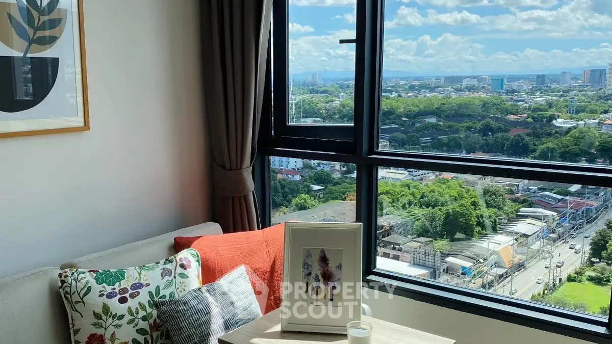 Charming living room with stunning city view from large window, cozy sofa, and stylish decor.