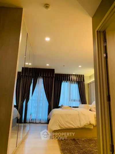 Luxurious bedroom with elegant decor and large windows offering natural light.