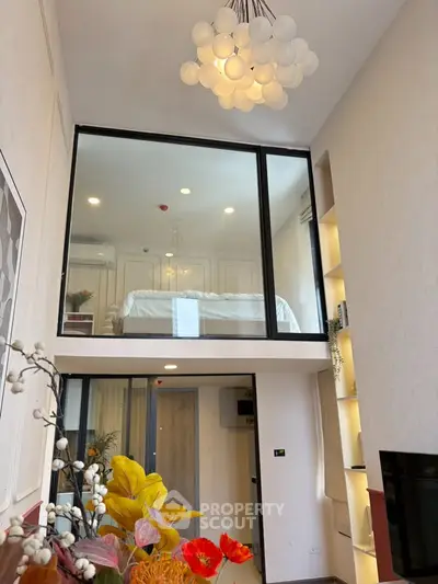 Modern loft apartment with high ceilings and stylish decor, featuring a unique mezzanine bedroom and elegant lighting.