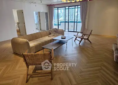 Spacious living room with modern furniture and city view balcony.