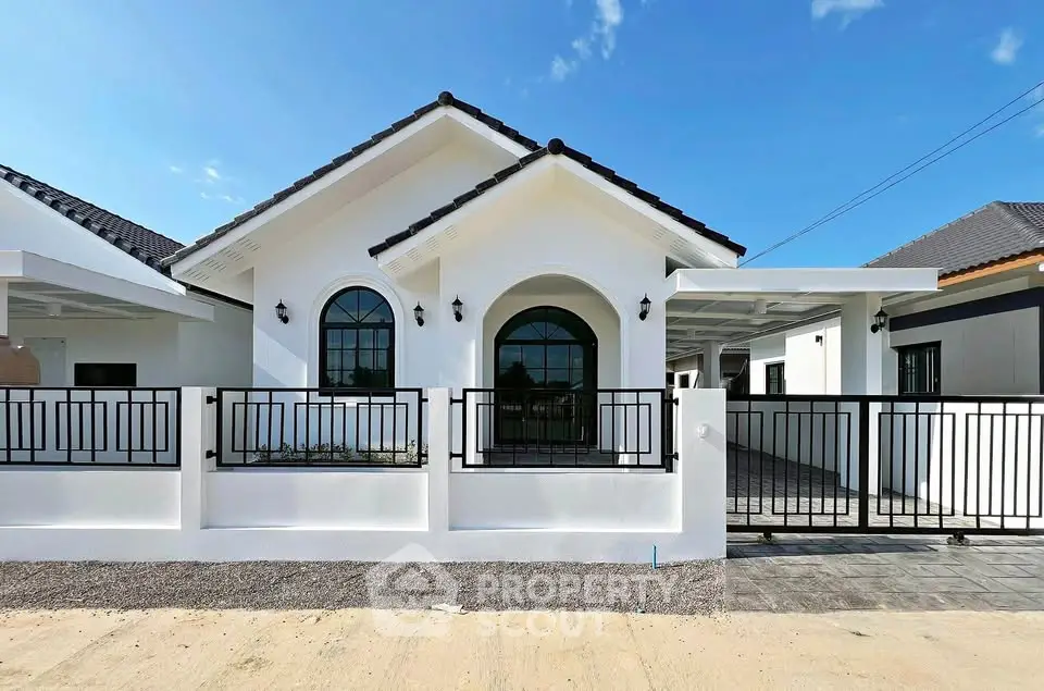 Charming modern white house with arched windows and gated driveway