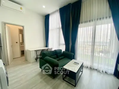 Modern living room with large windows and stylish furniture in a bright apartment.