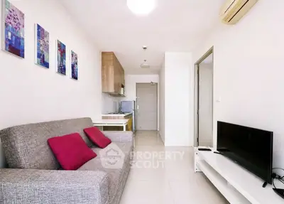 Modern living room with cozy sofa, vibrant artwork, and sleek TV setup in a stylish apartment.