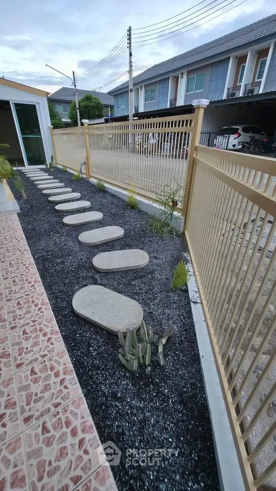 Charming garden pathway with stepping stones and modern fence in residential area