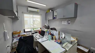 Compact home office with desk, shelves, and window view, ideal for productivity and organization.