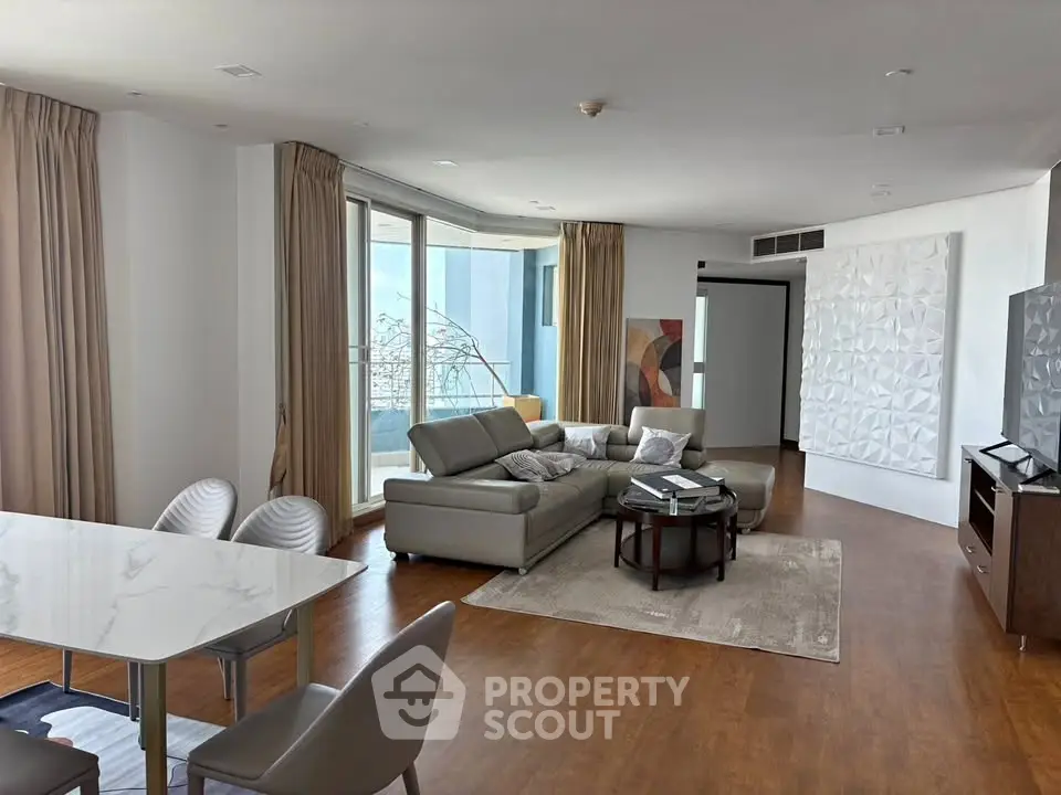 Spacious modern living room with elegant decor and large windows offering natural light.