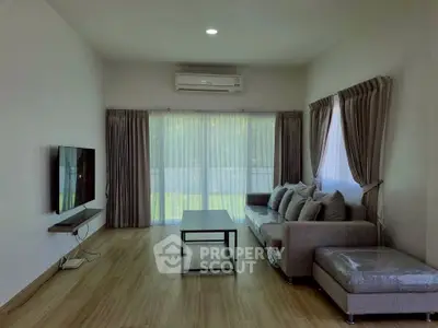 Spacious living room with modern decor and large windows offering natural light.
