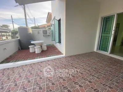 Spacious balcony with tiled flooring and outdoor seating, perfect for relaxation.
