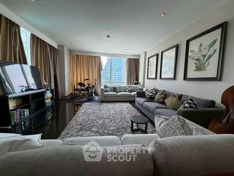 Spacious living room with modern decor and city view, featuring large windows and comfortable seating.