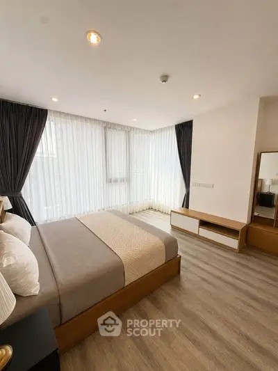 Spacious modern bedroom with large windows and elegant decor