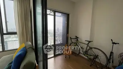 Cozy living room with balcony view, featuring a bicycle and guitar for a modern lifestyle.