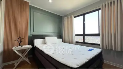Modern bedroom with large window offering stunning city views and stylish decor.