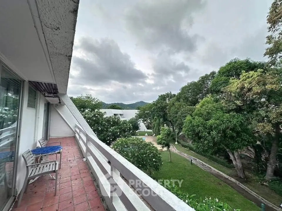 Spacious balcony with scenic garden view in a serene residential area.