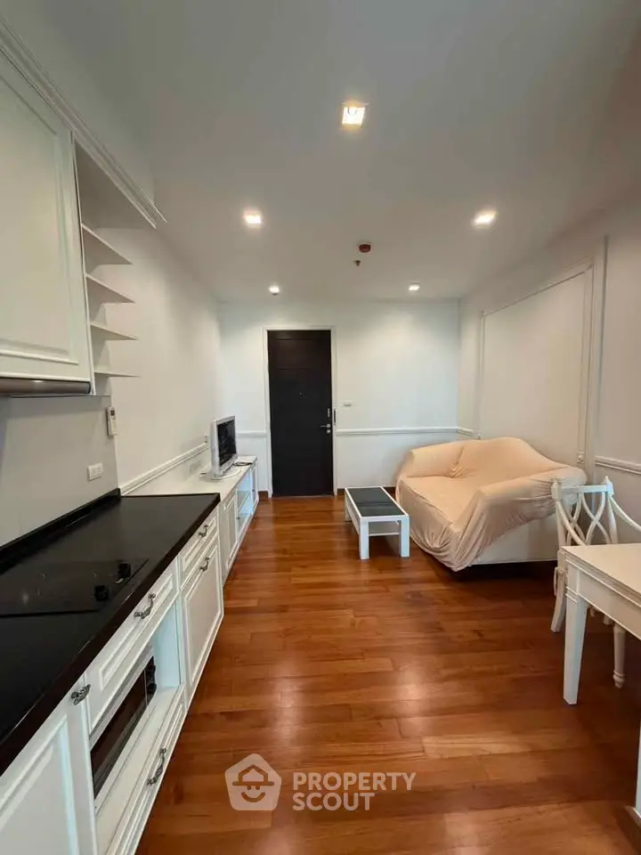 Charming living room with hardwood floors and cozy furnishings in a modern apartment.
