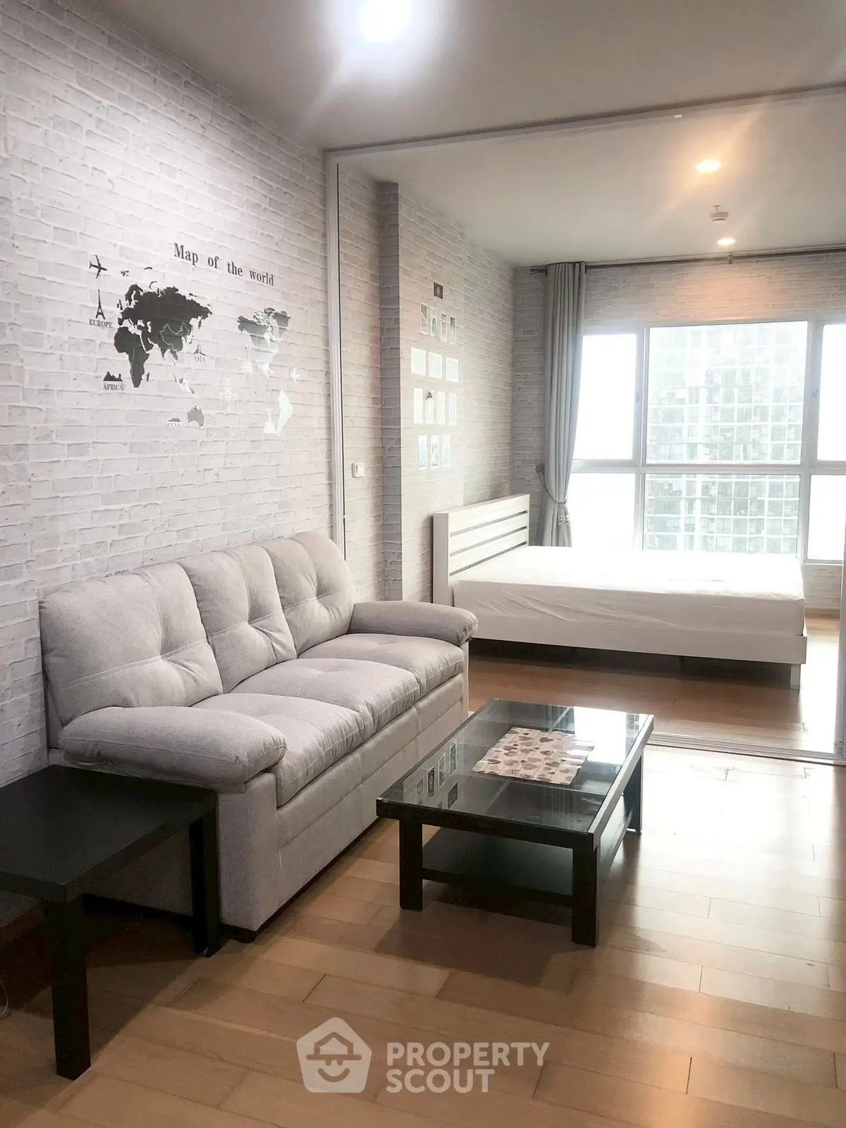 Modern studio apartment with cozy living area and large window view.