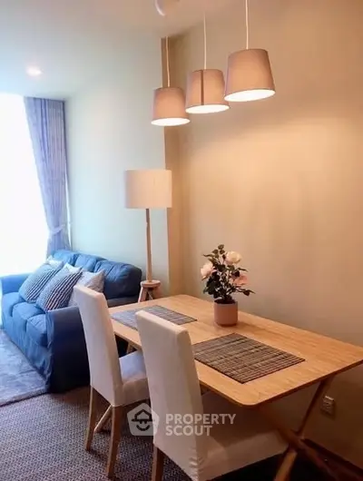 Cozy living room with dining area, stylish lighting, and comfortable seating.