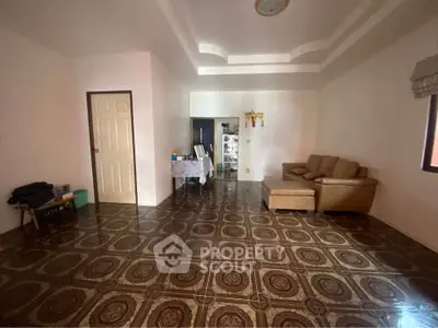 Spacious living room with unique patterned flooring and cozy seating area.