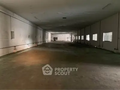 Spacious industrial warehouse interior with high ceilings and ample natural light.