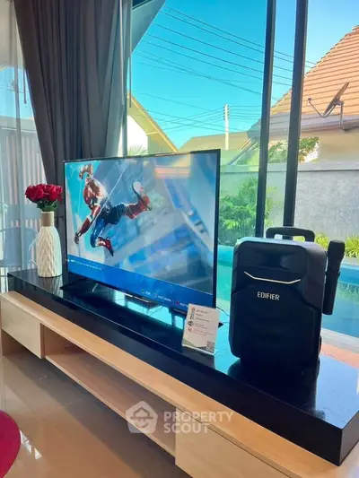 Modern living room with sleek entertainment setup and pool view