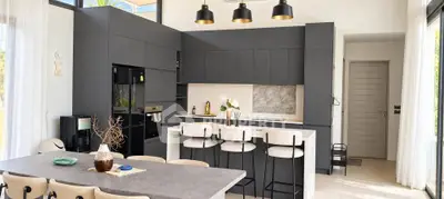 Modern kitchen with sleek black cabinetry and dining area in open layout