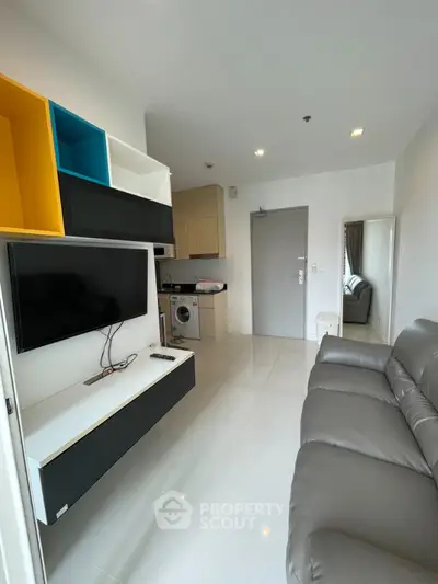 Modern living room with sleek furniture and compact kitchen in open layout apartment
