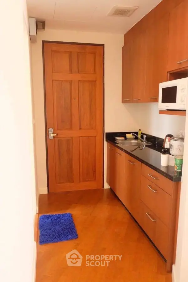 Compact kitchen with wooden cabinets and modern appliances